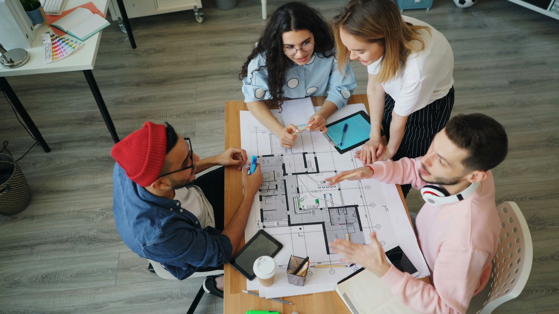 a group of people sitting around a table working on a project
